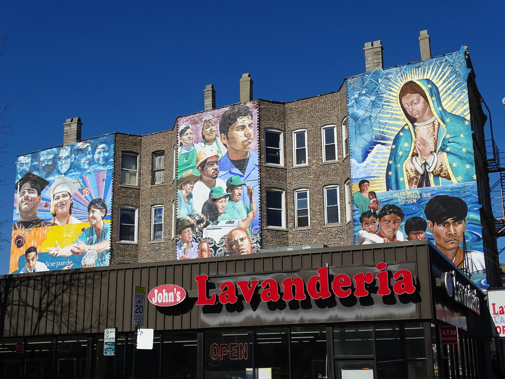 John's Lavanderia with murals on the building behind.