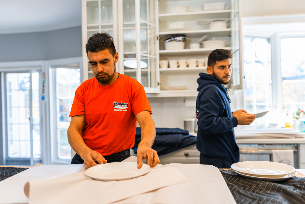 New city movers packing away dishes.
